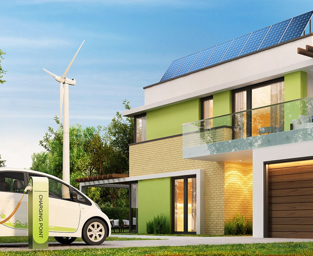 Ein modernes Haus mit Solarpanel, auf dem Dach davor steht ein Auto mit einer Ladestation und im Hintergrund steht ein Windrad.